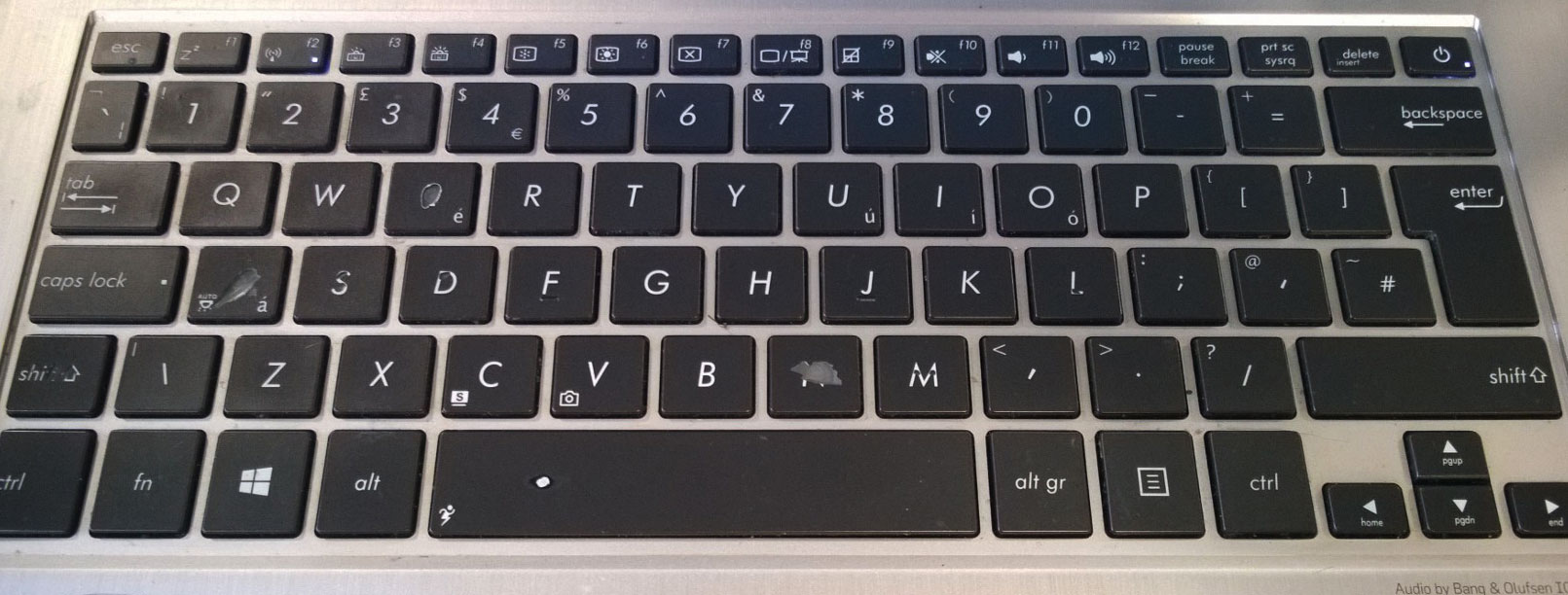 a laptop keyboard showing signs of wear from long term use - patina